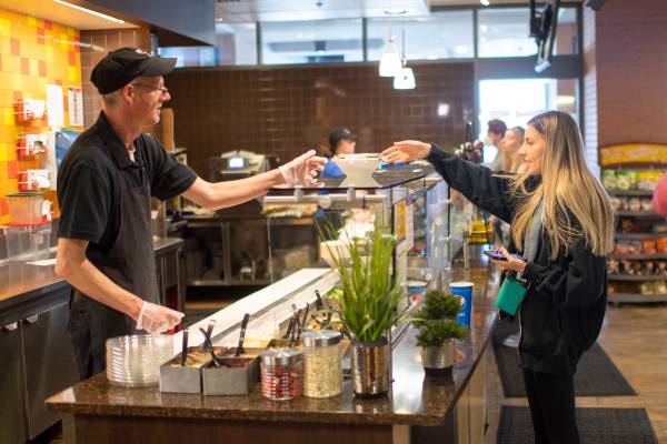 Employee handing a salad to a student